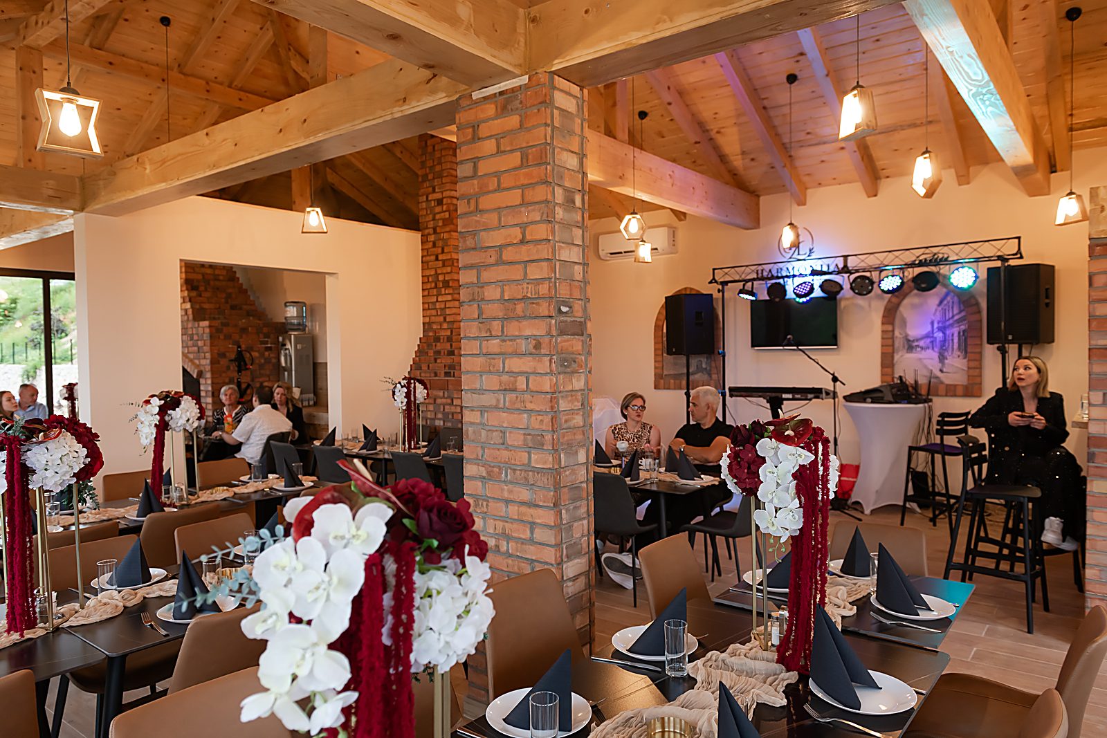 Sala sa pozornicom za muziku uživo i svečano postavljenim stolovima